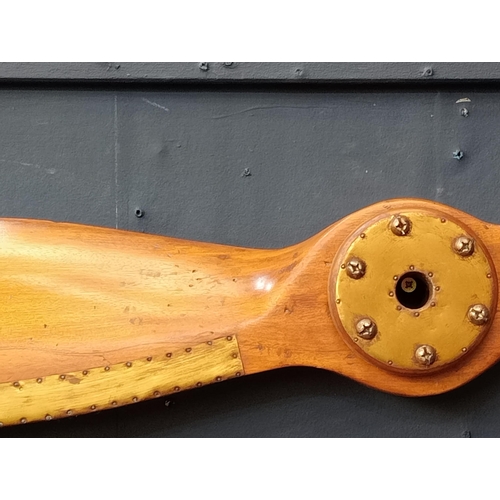 510 - A STAINED WOOD AND BRASS PROPELLER 150cm (w) x 8cm (d)