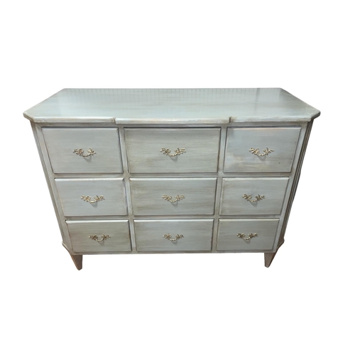 513 - A CONTINENTAL GREY PAINTED CHEST of breakfront outline the shaped top above nine short drawers with ... 