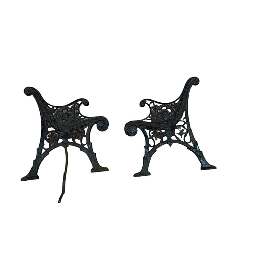 514 - A PAIR OF 19TH CENTURY CAST IRON BENCH ENDS with pierced C-scroll and flowerhead decoration on pad f... 