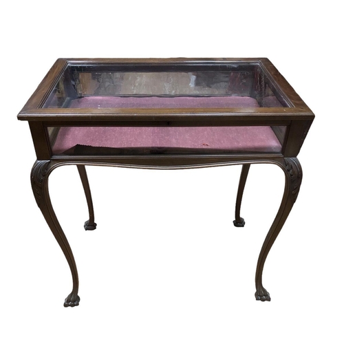 54 - AN EDWARDIAN CARVED MAHOGANY CURIO TABLE the rectangular hinged top with glazed panel and sides on f... 