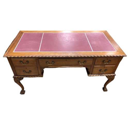 56 - A VINTAGE CHIPPENDALE DESIGN MAHOGANY DESK of rectangular outline the shaped top with tooled leather... 