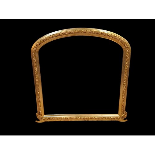 116 - A VICTORIAN STYLE GILT FRAME OVERMANTEL MIRROR the rectangular arched plate within a flowerhead and ... 