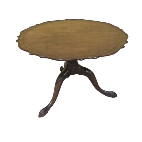 283 - A VINTAGE MAHOGANY COFFEE TABLE of circular outline the shaped top with pie crust rim raised on a ba... 