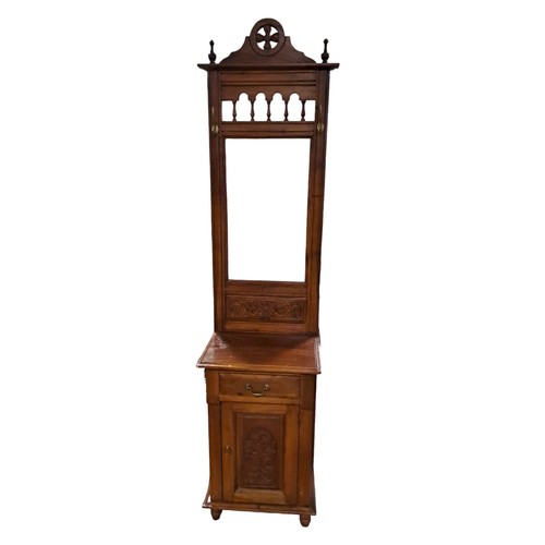 66 - A MAHOGANY HALLSTAND the rectangular mirror with baluster splats with two brass hooks above a carved... 