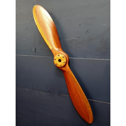 580 - A STAINED WOOD AND BRASS PROPELLER 100cm (w) x 8cm (d)