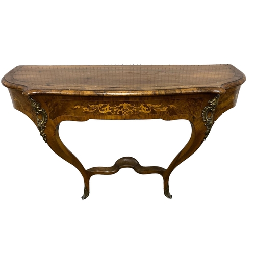 711 - A 19TH CENTURY CONTINENTAL WALNUT INLAID AND GILT BRASS MOUNTED CONSOLE TABLE of serpentine outline ... 