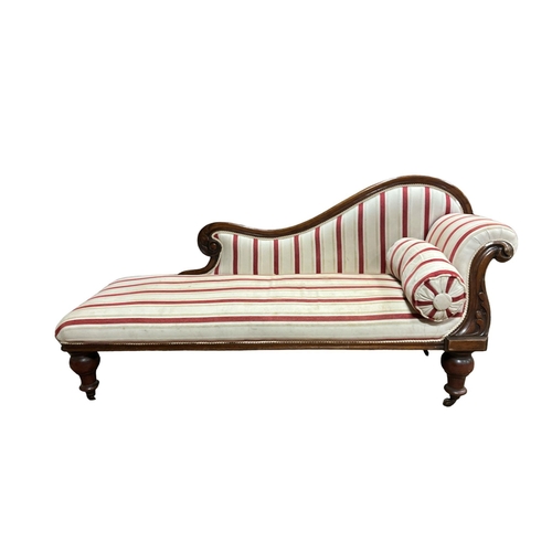 719 - A 19TH CENTURY MAHOGANY AND UPHOLSTERED CHAISE LONGUE the shaped top rail with foliate carving with ... 