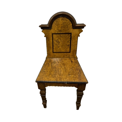 721 - AN ARTS AND CRAFTS BURR WALNUT HALL CHAIR the arched top rail with panel back and seat on square ste... 