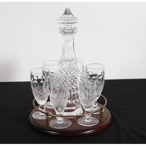 141 - A SET OF SIX WATERFORD CUT GLASS COLLEEN PATTERN GLASSES and decanter on hardwood stand with brass g... 