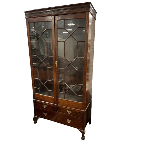 165 - A VINTAGE OAK TWO DOOR WARDROBE with astragal glazed doors containing a hanging rail the base with t... 