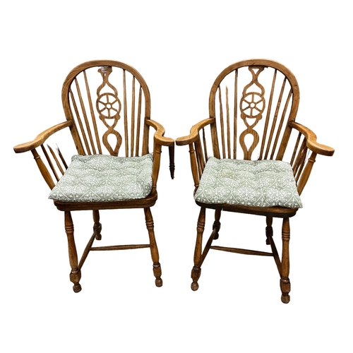 176 - A PAIR OF ELMWOOD WHEEL BACK WINDSOR CHAIRS on baluster legs joined by cross stretchers