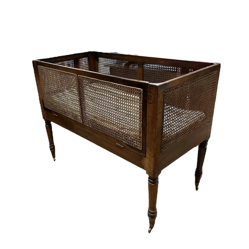 180 - A 19TH CENTURY MAHOGANY CHILD'S COT with caned panels on turned legs 85cm (h) x 113cm (w) x 56cm (d)... 