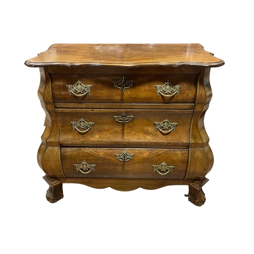 197 - A CONTINENTAL WALNUT CHEST of bombe outline the shaped top with three long graduated drawers between... 