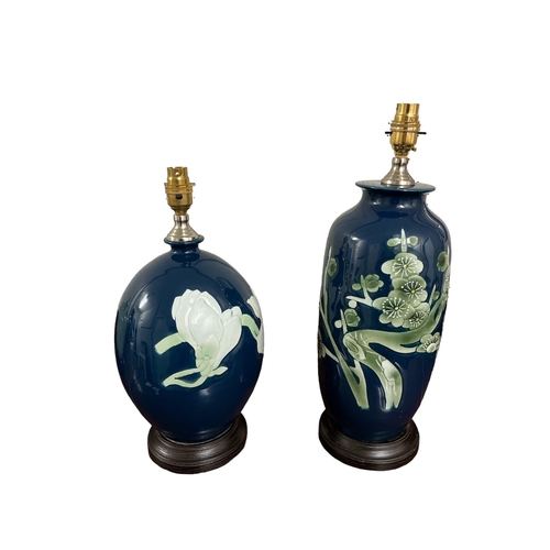 560 - TWO ORIENTAL PORCELAIN TABLE LAMPS the blue ground decorated with stylised flowerheads and foliage L... 