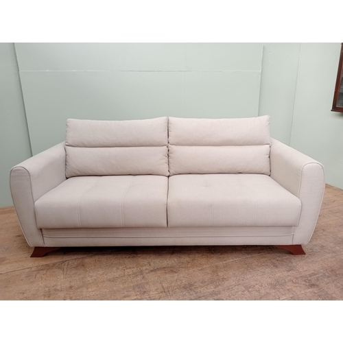 609 - A DESIGNER SETTEE with loose cushions and shaped arms on moulded legs 188cm (w) x 94cm (d)