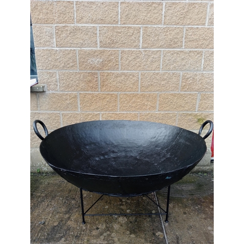 658 - A LARGE BLACK METAL FIRE PIT of dish form raised on a tubular base 86cm (h) x 130cm (d)