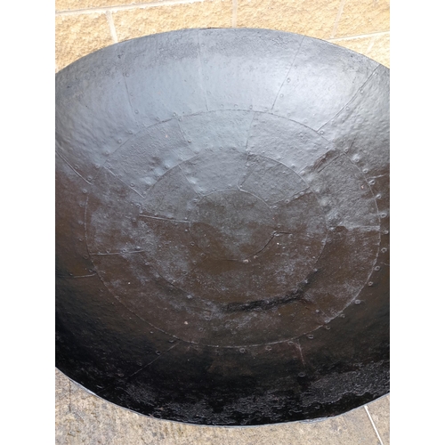 658 - A LARGE BLACK METAL FIRE PIT of dish form raised on a tubular base 86cm (h) x 130cm (d)