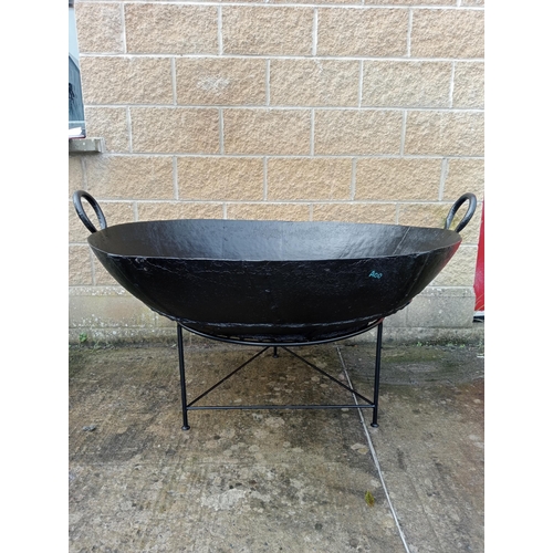 658 - A LARGE BLACK METAL FIRE PIT of dish form raised on a tubular base 86cm (h) x 130cm (d)