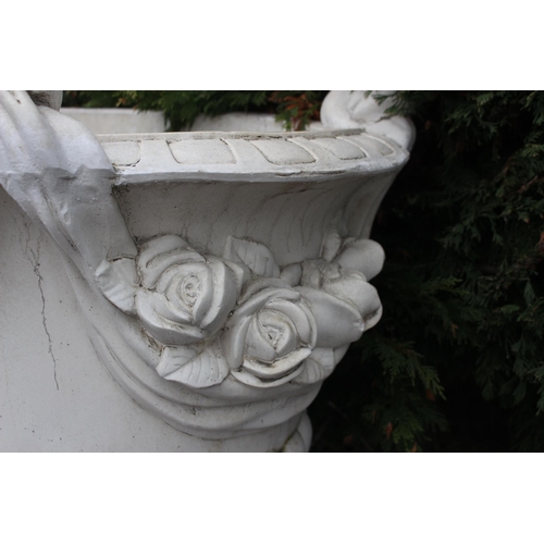 663 - A PAIR OF COMPOSITION STONE GARDEN URNS each of semi lobed campana form with flowerhead decoration a... 