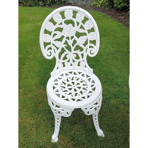 664 - A THREE PIECE CAST ALUMINIUM PATIO SUITE comprising a circular pierced top table on splayed legs tog... 