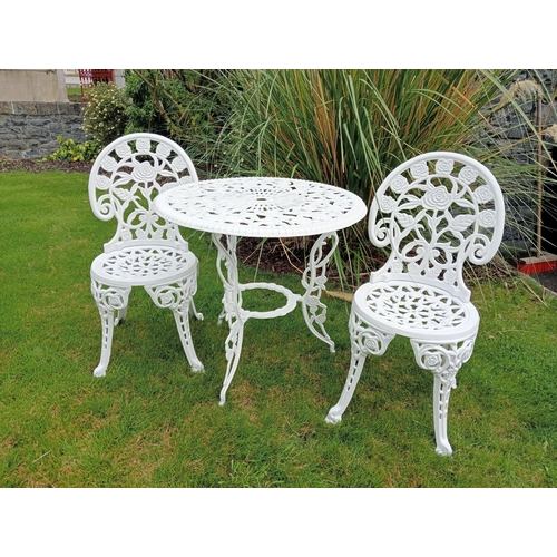 664 - A THREE PIECE CAST ALUMINIUM PATIO SUITE comprising a circular pierced top table on splayed legs tog... 