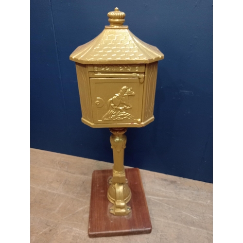 670 - A CAST IRON FREESTANDING POSTBOX of rectangular form with canted angles on hardwood base 110cm (h) x... 