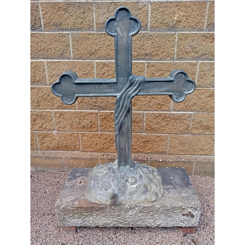 688 - A BRONZE CROSS on a naturalistic foot with sandstone plinth 150cm (h) x 100cm (w) x 50cm (d)