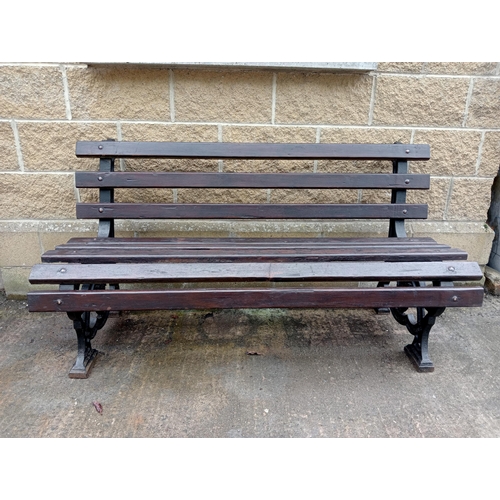 692 - A VICTORIAN CAST IRON AND STAINED WOOD GARDEN BENCH with slatted back and seat inscribed with Latin ... 