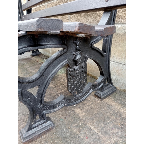 692 - A VICTORIAN CAST IRON AND STAINED WOOD GARDEN BENCH with slatted back and seat inscribed with Latin ... 