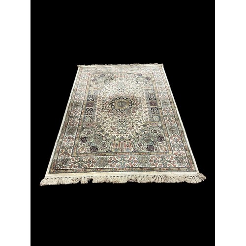 148 - A BEIGE AND MULTICOLOURED RUG the central panel filled with stylised flowerheads and foliage within ... 