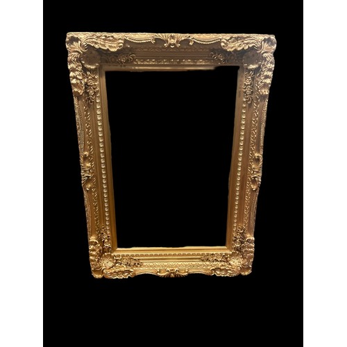 540 - A CARVED WOOD GILT FRAME MIRROR the rectangular bevelled glass plate within a flowerhead and foliate... 