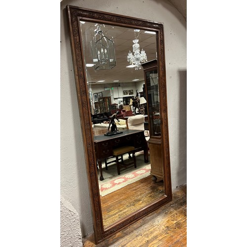 300 - A CONTINENTAL CARVED FRAMED MIRROR with rectangular bevelled glass plate 228cm (h) x 121cm (w)