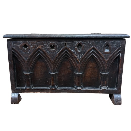 172 - A 19TH CENTURY OAK MINIATURE TRUNK the rectangular hinged lid above a gothic tracery frieze on mould... 