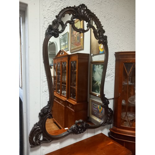 49 - A STAINED WOOD CARVED FRAME MIRROR the shaped plate within a C-scroll and foliate carved frame with ... 