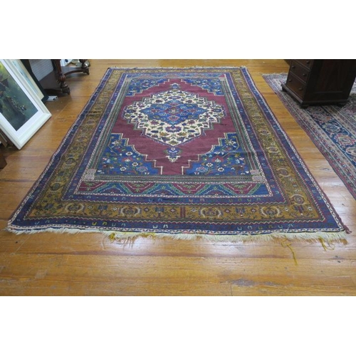 362 - AN ORIENTAL WOOL RUG with indigo wine and light brown field with central panel filled with sylised f... 