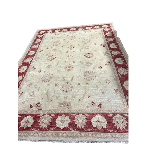 363 - A WOOL RUG the beige ground the central panel with stylised flowerheads and foliage within a conform... 