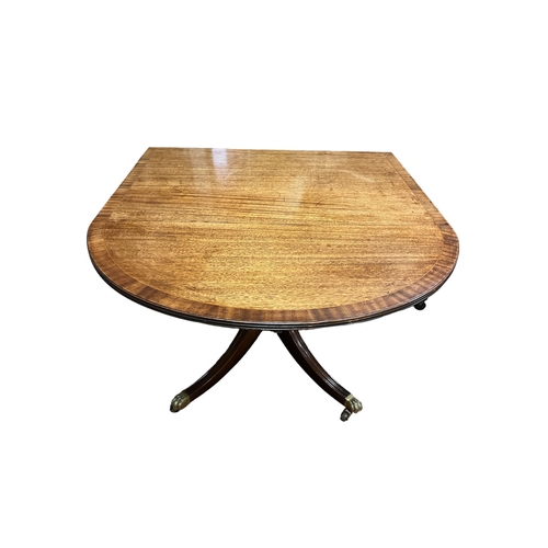 431 - A REGENCY STYLE MAHOGANY CROSSBANDED DROP LEAF TABLE the oval hinged top on quadruped splayed legs w... 