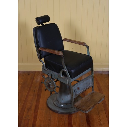 452 - A VINTAGE CAST IRON PINE AND UPHOLSTERED ADJUSTABLE BARBER'S CHAIR with foot rest raised on a circul... 