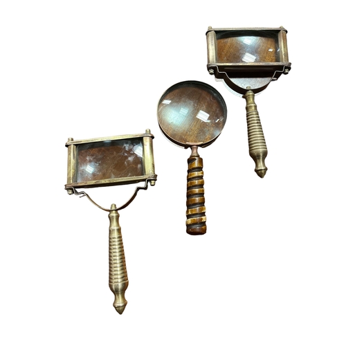 548 - A PAIR OF BRASS MAGNIFYING GLASSES each with a turned handles together with a similar example (3)