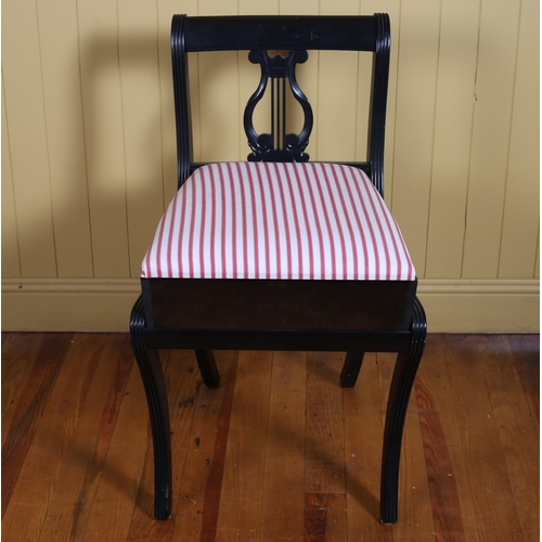 166 - A REGENCY STYLE EBONISED MUSIC CHAIR with hinged seat on sabre legs