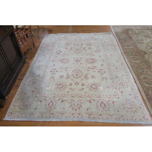 177 - A WOOL RUG the beige ground with central panel filled with flowerheads and foliage within a conformi... 