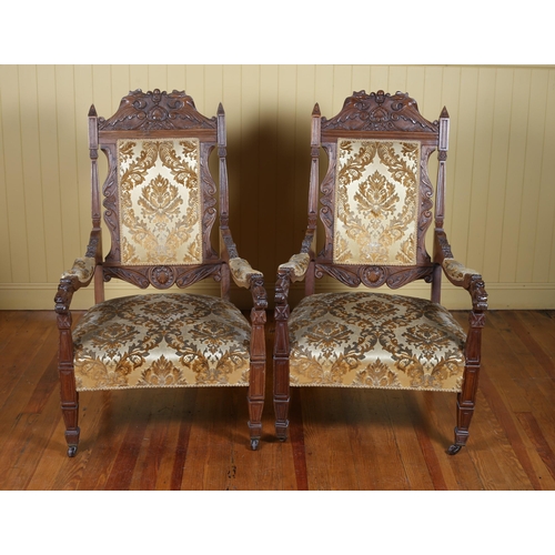 211 - A PAIR OF 19TH CENTURY CARVED OAK AND UPHOLSTERED ARMCHAIRS each with an upholstered panel and seat ... 