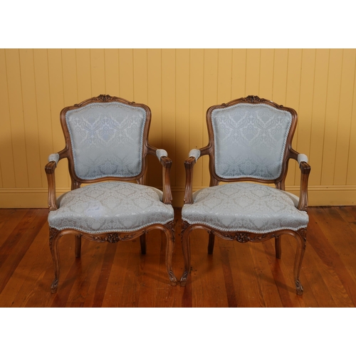 402 - A PAIR OF FRENCH CARVED WALNUT AND UPHOLSTERED SALON CHAIRS each with a foliate carved top rail abov... 