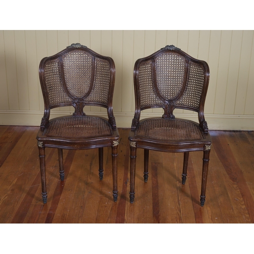 407 - A PAIR OF CONTINENTAL STAINED WOOD GILT BRASS AND CANED SIDE CHAIRS each with a curved back and shap... 