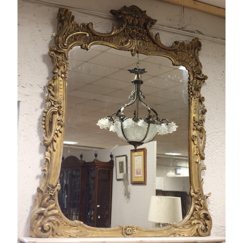 440 - A 19TH CENTURY CARVED GILTWOOD OVERMANTEL MIRROR the shaped plate within a foliate and flowerhead ca... 