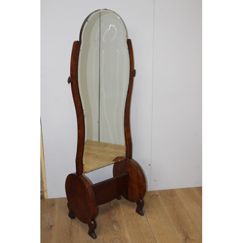 476 - AN ART DECO WALNUT CHEVAL MIRROR the shaped bevelled glass plate raised on a moulded stand with cyli... 