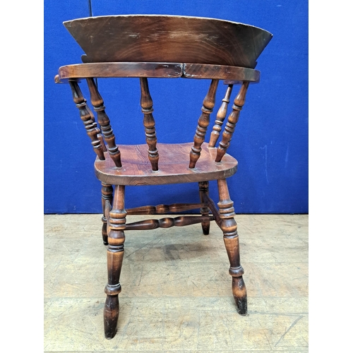 477 - A VINTAGE OAK SMOKER'S BOW CHAIR with baluster splats and panel seat on conforming legs 78cm (h) 69c... 