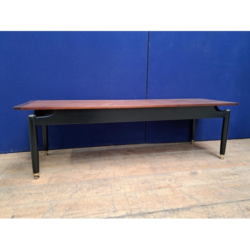 480 - A RETRO TEAK COFFEE TABLE of rectangular form on cylindrical tapering legs with brass pad feet 48cm ... 