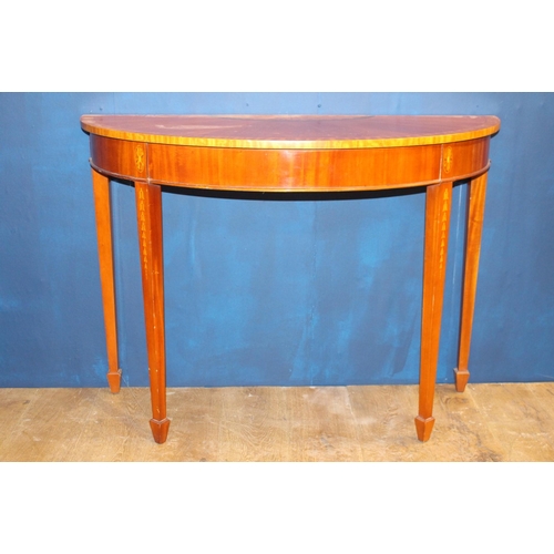 485 - A GEORGIAN STYLE MAHOGANY CROSSBANDED SIDE TABLE of demi lune outline raised with square tapering le... 