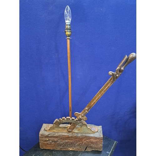 487 - A VINTAGE CAST IRON TABLE LAMP in the form of a handbrake raised on a hardwood stand 90cm (h) x 43cm... 